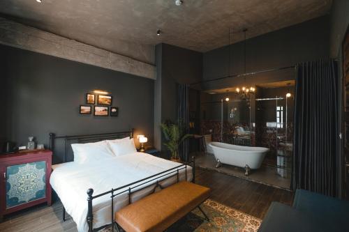 a bedroom with a large bed and a bath tub at The Chum Boutique in Hue