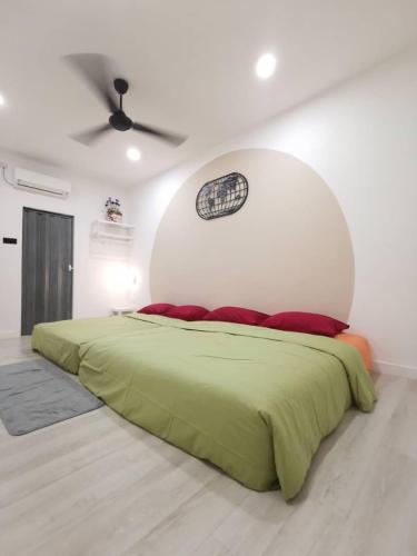 a bedroom with a green bed with a white wall at Wellson Home Ipoh 6 (15px+)温馨舒适奶油风民宿15人 in Ipoh
