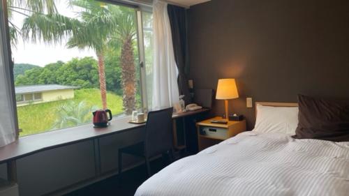 a bedroom with a bed and a window with a palm tree at Shonan OVA in Yokosuka