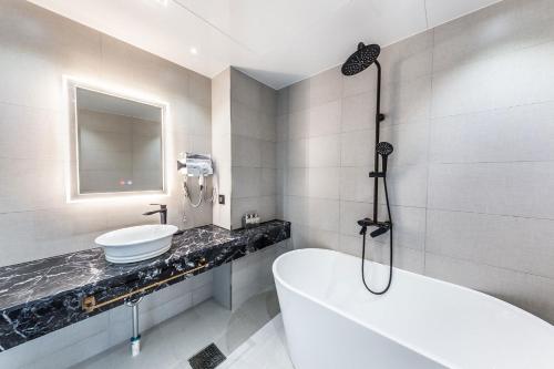 a bathroom with a tub and a sink at The Post Hotel in Seoul