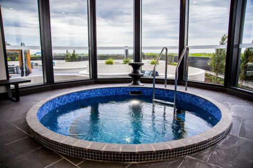 a hot tub in a room with windows at The Sebel Melbourne Malvern in Melbourne