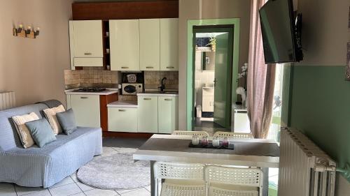 a kitchen and living room with a couch and a table at Bon Bon del Corso con terrazzo e aria condizionata in Asti