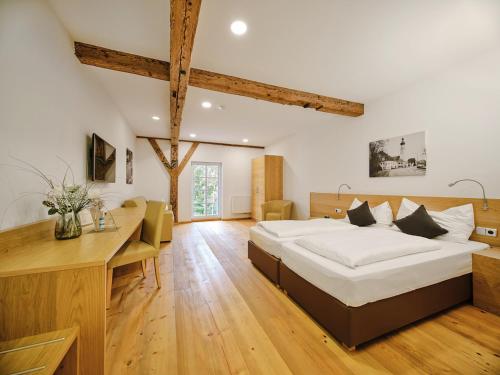 a large bedroom with a large bed and a desk at Hofwirthotel in Sankt Martin im Innkreis