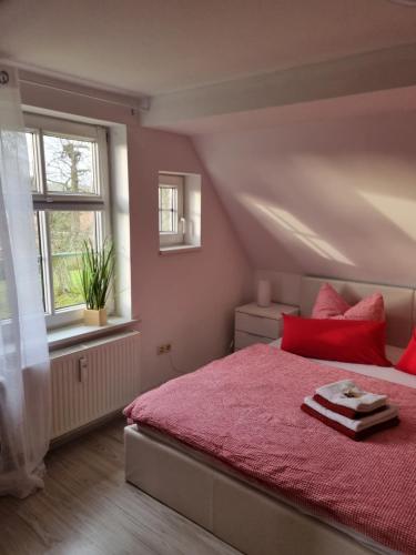 a bedroom with a red bed and a window at Storchenhof Engel in Katzow