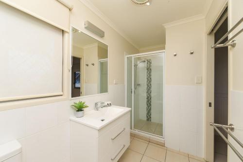 a white bathroom with a sink and a shower at Reflections Corindi Beach - Holiday Park in Corindi