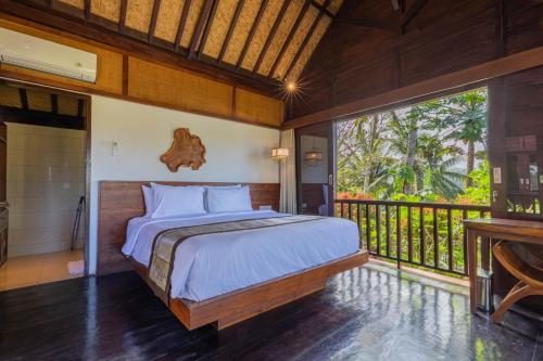 1 dormitorio con 1 cama y balcón en Amanuba Ersadeva Resort, en Pulukan