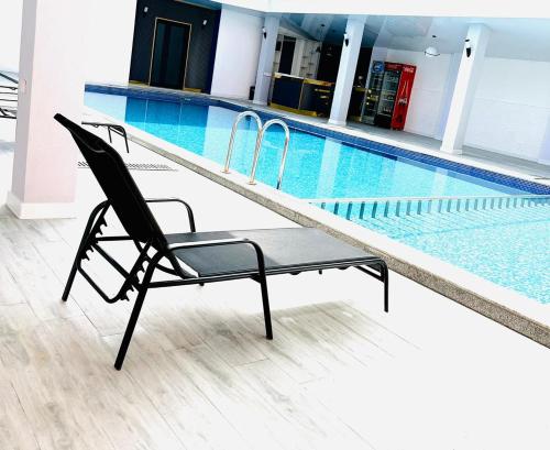 a black chair sitting next to a swimming pool at Hotel Albatros in Ureki