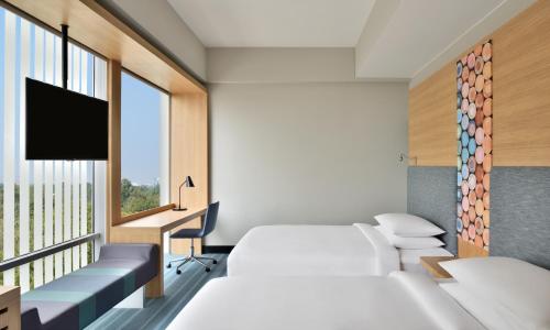 a hospital room with two beds and a window at Aloft New Delhi Aerocity in New Delhi