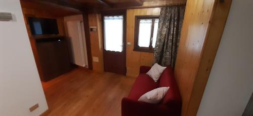 a living room with a red couch and a television at Da Ivana in Alagna Valsesia