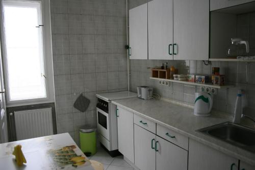 - une cuisine avec des placards blancs et un évier dans l'établissement Astoria Downtown, à Budapest