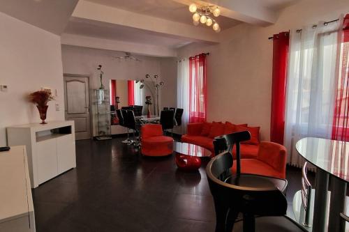 uma sala de estar com cadeiras vermelhas e uma mesa em L'oiseau du paradis em Narbona