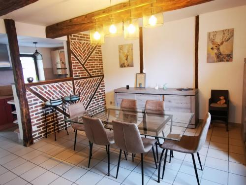 普羅豐德維耶的住宿－Les 4 Arbres，一间设有玻璃桌和椅子的用餐室