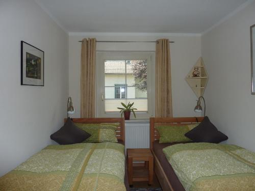 1 dormitorio con 2 camas y ventana en Haus Edelsbergblick en Nesselwang