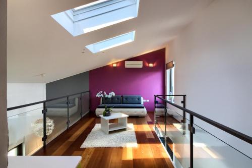 ein Wohnzimmer mit einem Sofa und einer lila Wand in der Unterkunft Beautiful villa Eva with private pool near the beach in Šišan