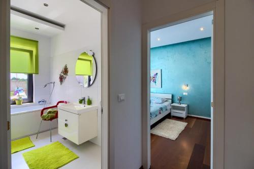 ein Schlafzimmer mit einem Bett und ein Badezimmer in der Unterkunft Beautiful villa Eva with private pool near the beach in Šišan