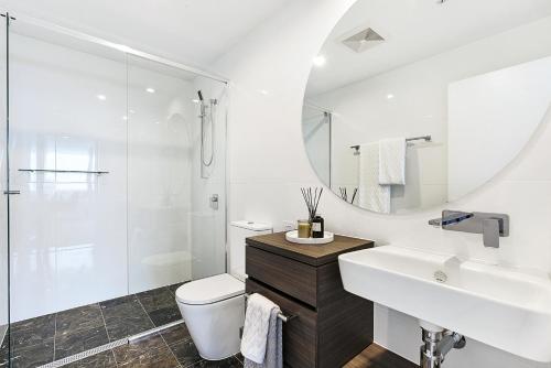 a bathroom with a sink and a toilet and a shower at Qube Broadbeach in Gold Coast
