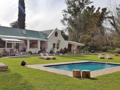 a house with a swimming pool in the yard at Silos Guesthouse in Addo