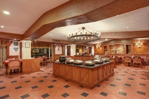 a large room with a dining area and a chandelier at The Cama - A Sabarmati Riverfront Hotel in Ahmedabad