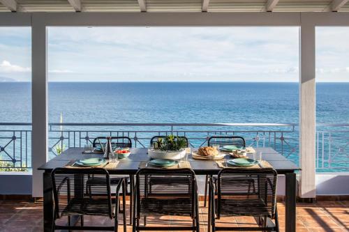 a dining room table with a view of the ocean at SEETHESEA in Kaligata