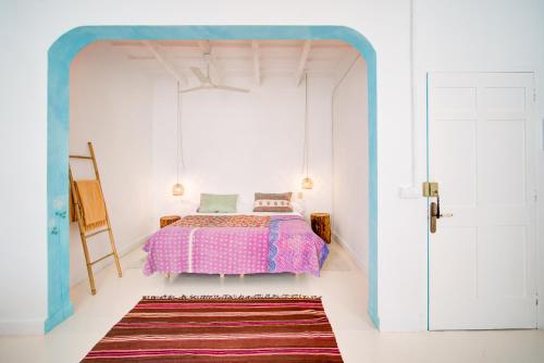 a bedroom with a bed with a blue frame at La Cayena Rooms in Ciutadella