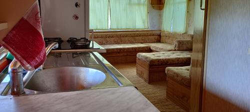 a kitchen with a sink and a living room with a couch at Domek nad Stawami - Warmia in Jonkowo