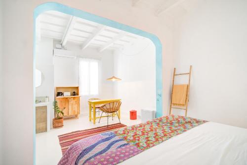 a bedroom with a bed and a table with a chair at La Cayena Rooms in Ciutadella