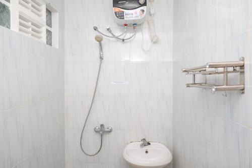 a white bathroom with a toilet and a shower at RedDoorz Syariah at Griya Merbotan Demak in Demak