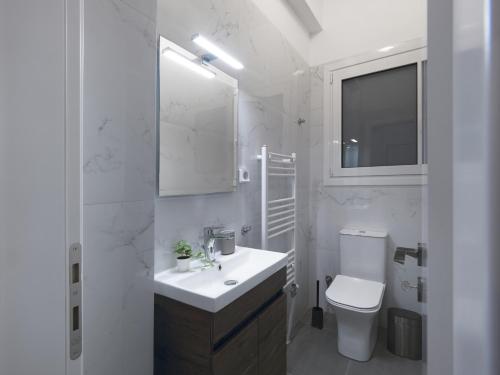 a white bathroom with a sink and a toilet at Aiginitou6 in Athens