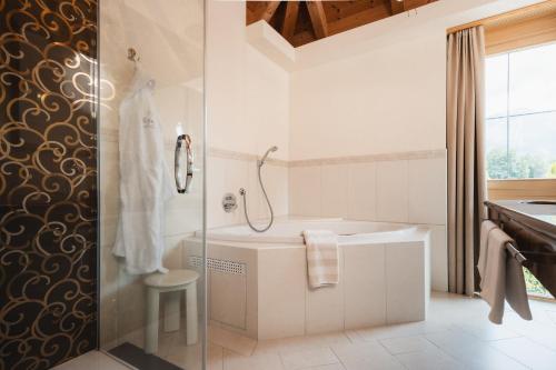 a white bathroom with a tub and a sink at Alpine Resort Goies Superior in Ladis