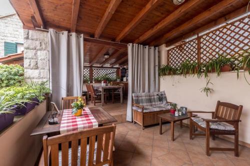 an outdoor patio with tables and chairs and a table at Apartments and Rooms Villa Lina in Split
