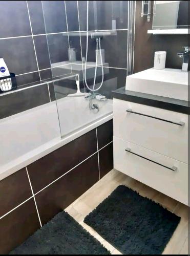 une salle de bain avec un lavabo, une baignoire et un miroir dans l'établissement La Romantique, à Bourges