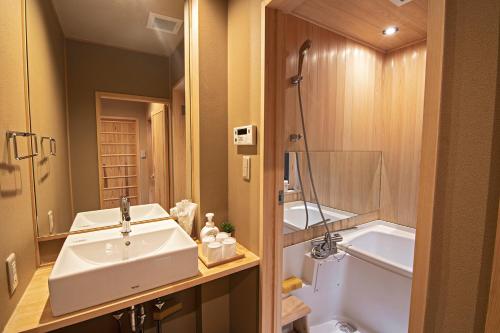 a bathroom with a sink and a toilet and a tub at Konayuki Inn Machiya 粉雪の宿 6min walk from Kyoto St in Kyoto