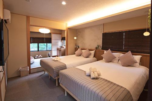 a bedroom with two beds with stuffed animals on them at Konayuki Inn Machiya 粉雪の宿 6min walk from Kyoto St in Kyoto