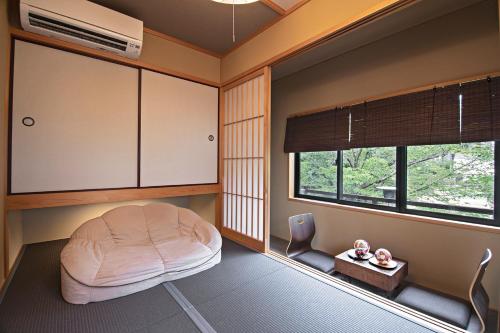 a room with a round bed and two windows at Konayuki Inn Machiya 粉雪の宿 6min walk from Kyoto St in Kyoto