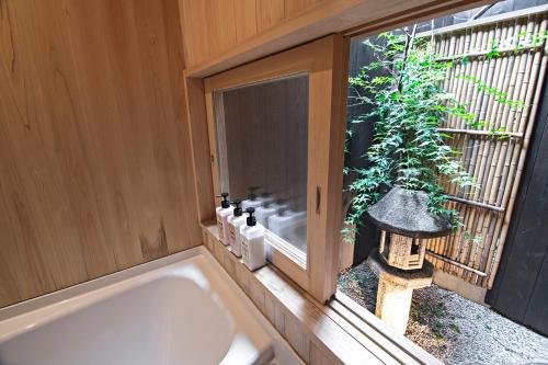 a bathroom with a bath tub and a window at Konayuki Inn Machiya 粉雪の宿 6min walk from Kyoto St in Kyoto