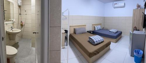 una piccola camera con due letti e un bagno di HeMei Homestay a Ho-mei