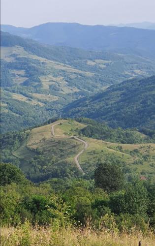 a view of a valley from a hill with a road at Almost Heaven - cabană cu vedere în Apuseni in Cîmpeni
