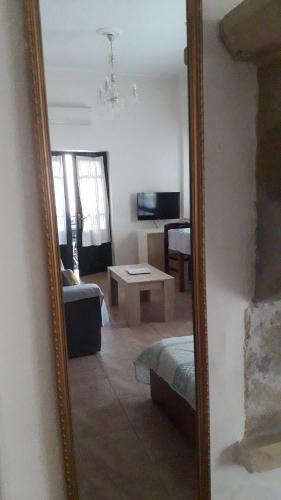 a mirror reflecting a living room with a couch and a table at Villa 1930 ground floor in Vóroi