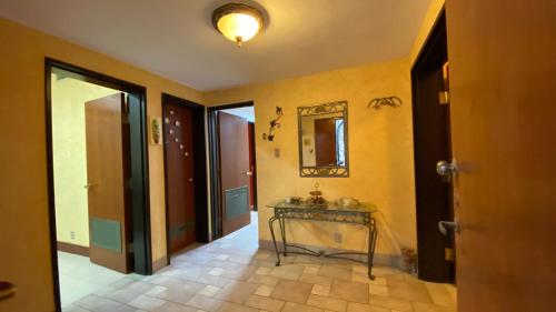 korytarz z żółtymi ścianami, stołem i lustrem w obiekcie فيلا رضوى الخير w mieście Madīnat Yanbu‘ aş Şinā‘īyah