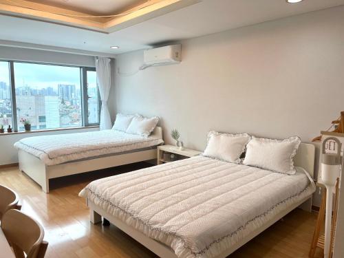 1 dormitorio con 2 camas y ventana grande en Hongik univ station Exit 1 en Seúl