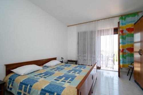 Un dormitorio con una cama con una colcha colorida encima. en Kuća Zora, en Zaglav
