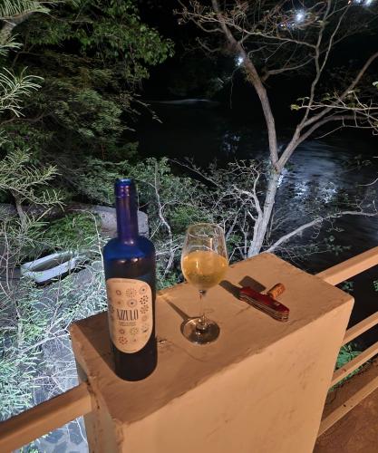 a bottle of wine and a glass on a box at Samira's Birds & Butterflies Park-Spashram Ganga Beach Retreat in Rishīkesh