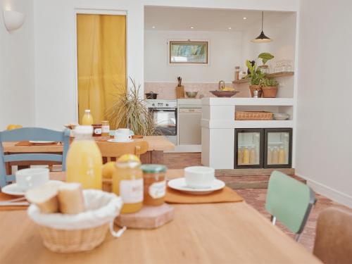 a kitchen and dining room with a table with food on it at La Boule d'Or - Auberge créative in Clamecy