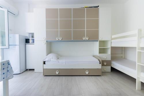 a bedroom with a large white bed and cabinets at Appartamento Ashur Mondello in Palermo