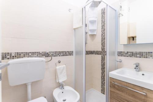 a bathroom with a toilet and a sink and a shower at Appartamento Ashur Mondello in Palermo