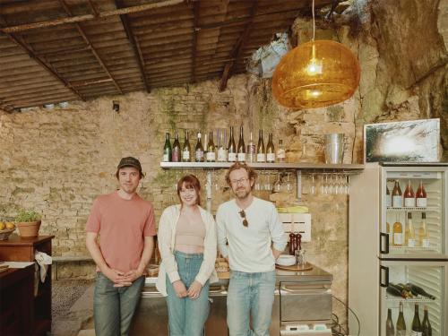 a group of three people standing in front of a bar at La Boule d'Or - Auberge créative in Clamecy