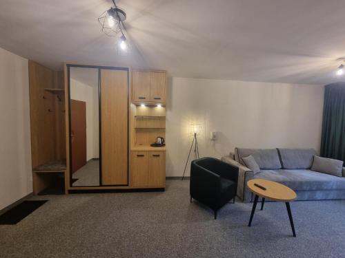 ein Wohnzimmer mit einem Sofa und einem Tisch in der Unterkunft SP ZOZ Sanatorium Uzdrowiskowe MSWiA w Krynicy-Zdroju in Krynica-Zdrój