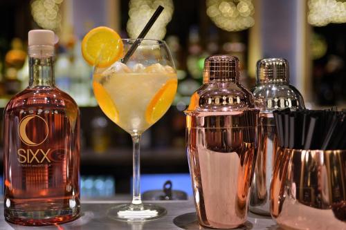 a drink in a glass next to a bottle of alcohol at Van der Valk Hotel Tiel in Tiel