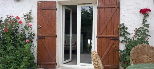 une porte ouverte sur une maison avec des roses dans l'établissement Campagne Carbonel, à Aix-en-Provence