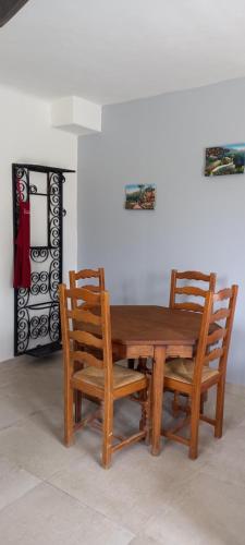 une table en bois et deux chaises assises à côté d'un mur dans l'établissement Campagne Carbonel, à Aix-en-Provence